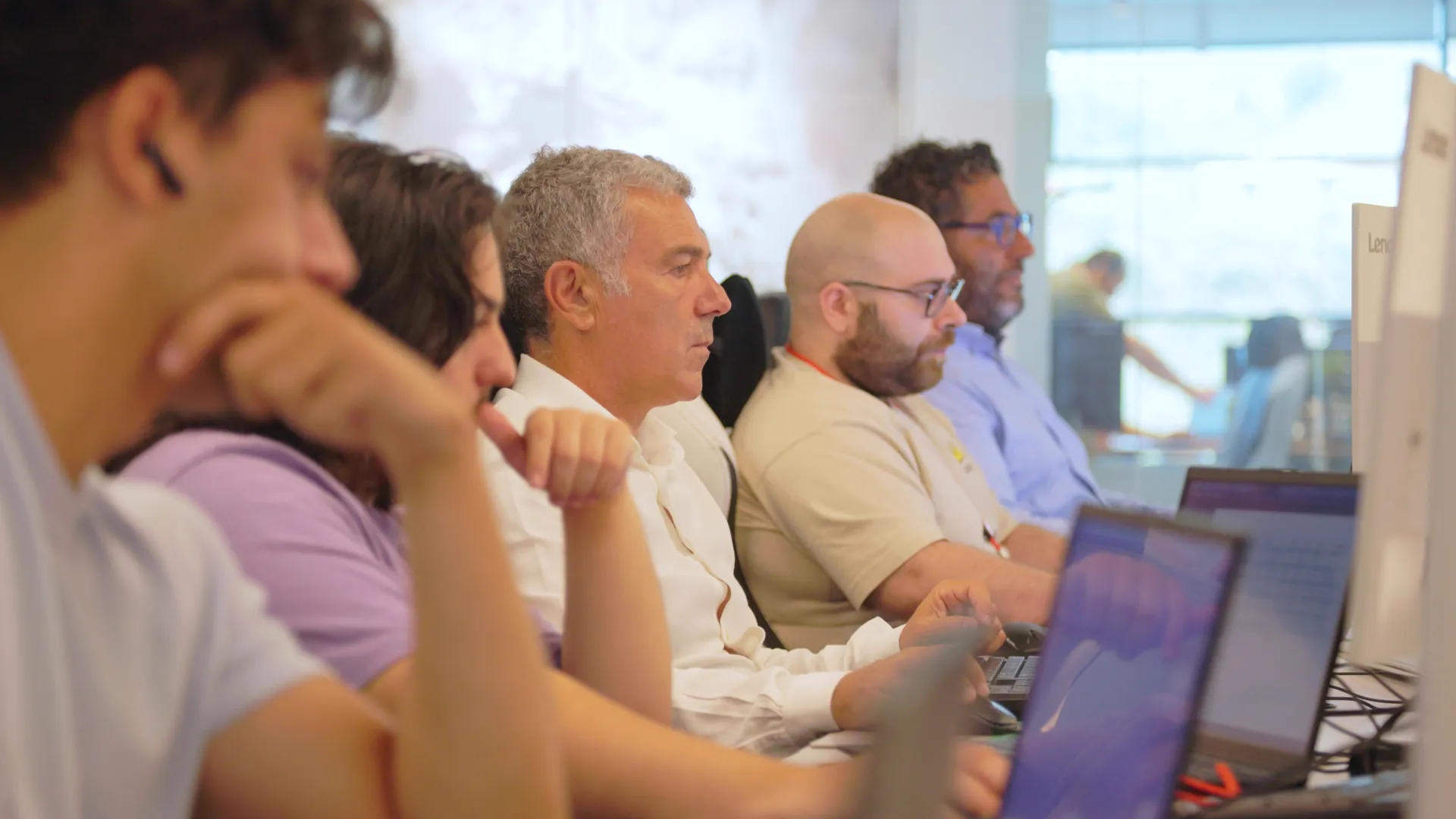 Colleagues concentrating on their laptops at a shared desk